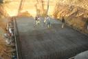 Der linke Kollege glättet den Beton - ganz links auf dem Dreibein ist das Lasermessgerät zu sehen.